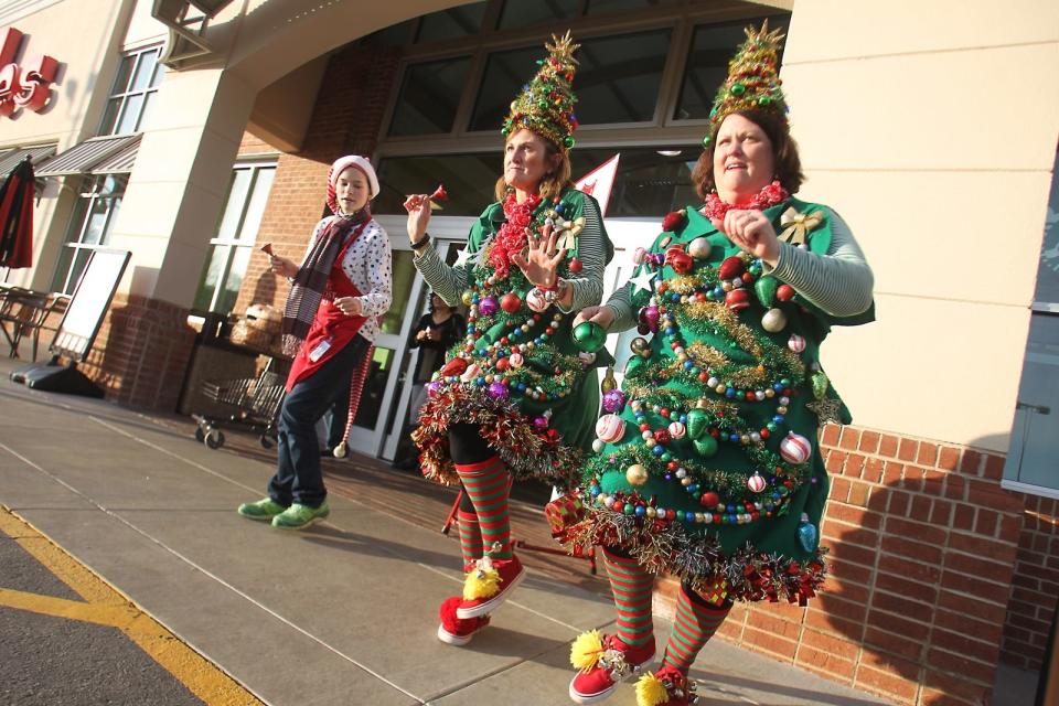 The NYC Tree Girls, Carol Ann Hoard and Tisha Dedmon dance with Allie McArthur and spread joy outside of Ingles on highway 74 to help raise funds for the Salvation Army's red kettle campaign Wednesday afternoon. Hannah Dunaway/ The Star