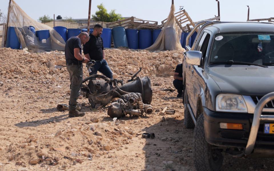 A police officer inspects the remains of a rocket booster that, according to Israeli authorities critically injured a 7-year-old girl