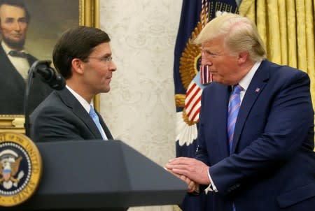 U.S. President Donald Trump shakes hands with Mark Esper after Esper was sworn in as the new Secretary of Defense in the Oval Office of the White House in Washington