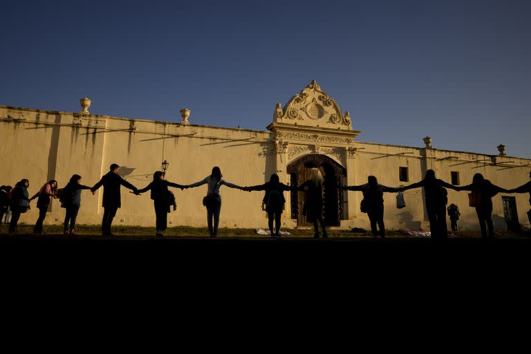 Women protest holding hands, surrounding the San Bernardo Convent in Salta, Argentina, Tuesday, May 3, 2022. Feminist groups protest in support of a community of cloistered nuns who have accused the Archbishop of Salta province Mario Antonio Cargnello, and other church officials of gender-based psychological and physical violence.