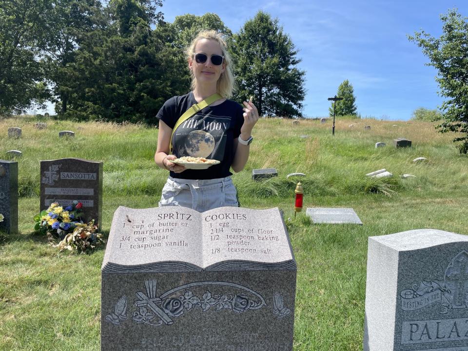 Rosie standing behind the gravestone with the spritz cookie recipe