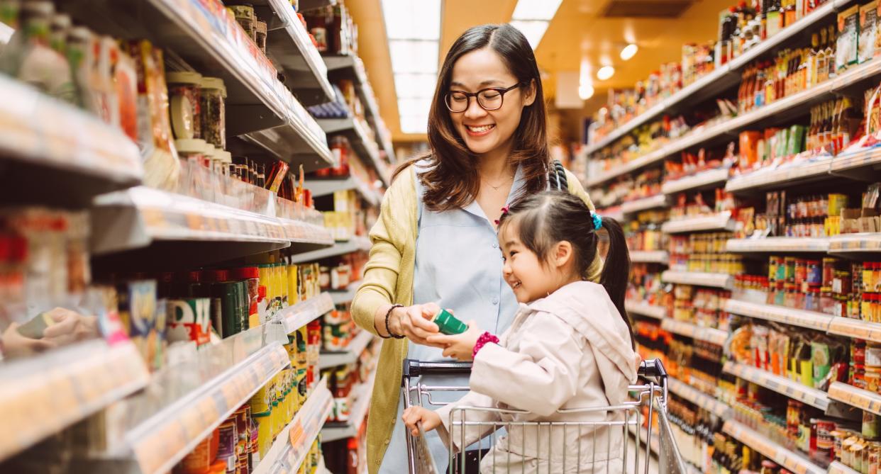 A mother and daughter do a food shop at a supermarket. The young daughter sits in the trolley. (Getty Images)