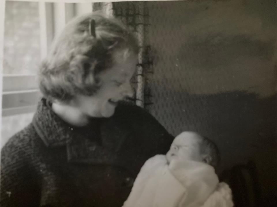 A black and white photograph of a mother looking at her sleeping baby.