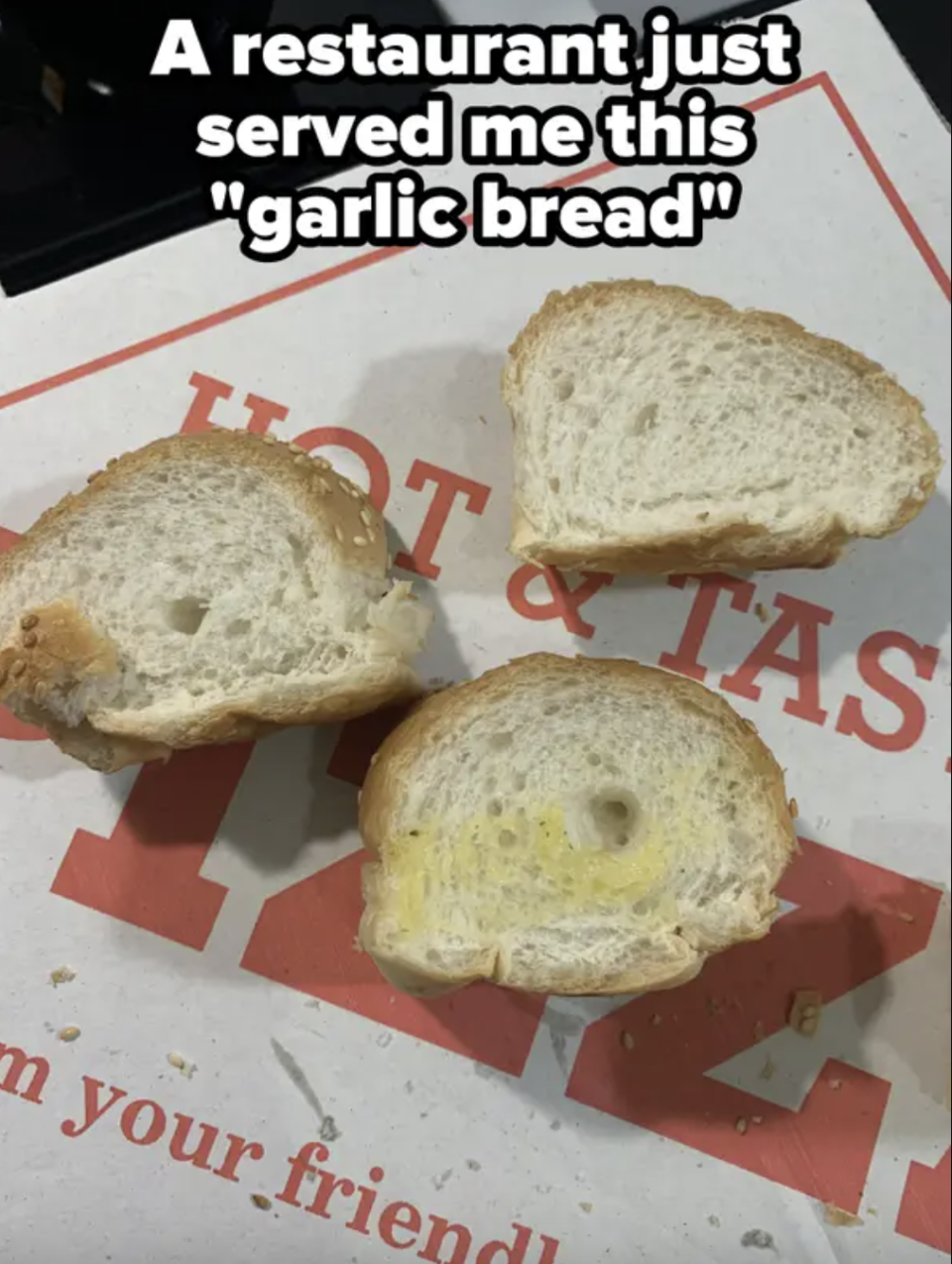 Three pieces of plain bread with faint butter marks labeled as "garlic bread" on a takeaway pizza box with some text