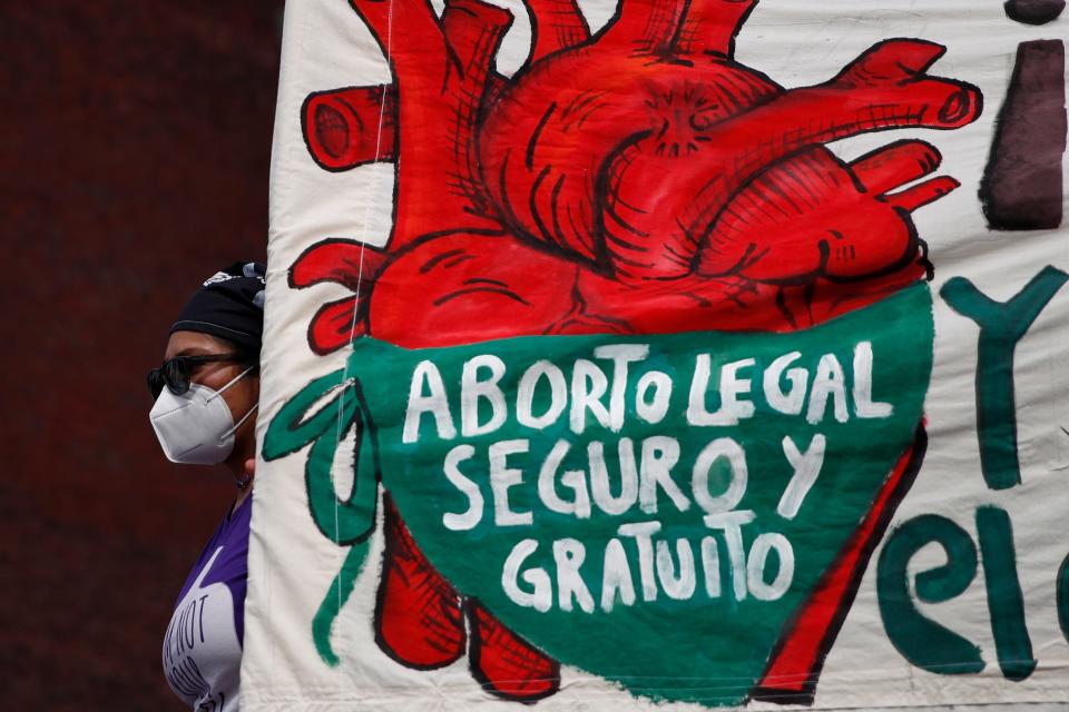 At a demonstration in Mexico City on in 2020, a woman holds a banner reading in Spanish, "Legal, safe and free abortion."