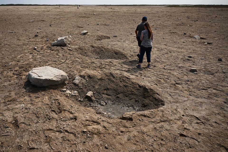 Members of the public walk through a debris field at the launch pad on 22 April, 2023, after the SpaceX Starship lifted off on 20 April for a flight test from Starbase in Boca Chica, Texas (Getty Images)