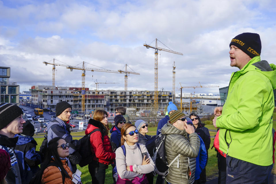 Tour guide Thorhallur Thorhallsson talks to tourists during a city walk around Reykjavik, Iceland, Sunday Oct. 7, 2018. After the collapse of Iceland's financial sector the country's economy has been focused on tourism. On the 10-year anniversary of the financial crash, now known as “hrunid”, the collapse, the last in a series of prosecutions of those deemed responsible has started, and Icelanders look for some closure after years of reckoning and reconstruction. (AP Photo/Egill Bjarnason)