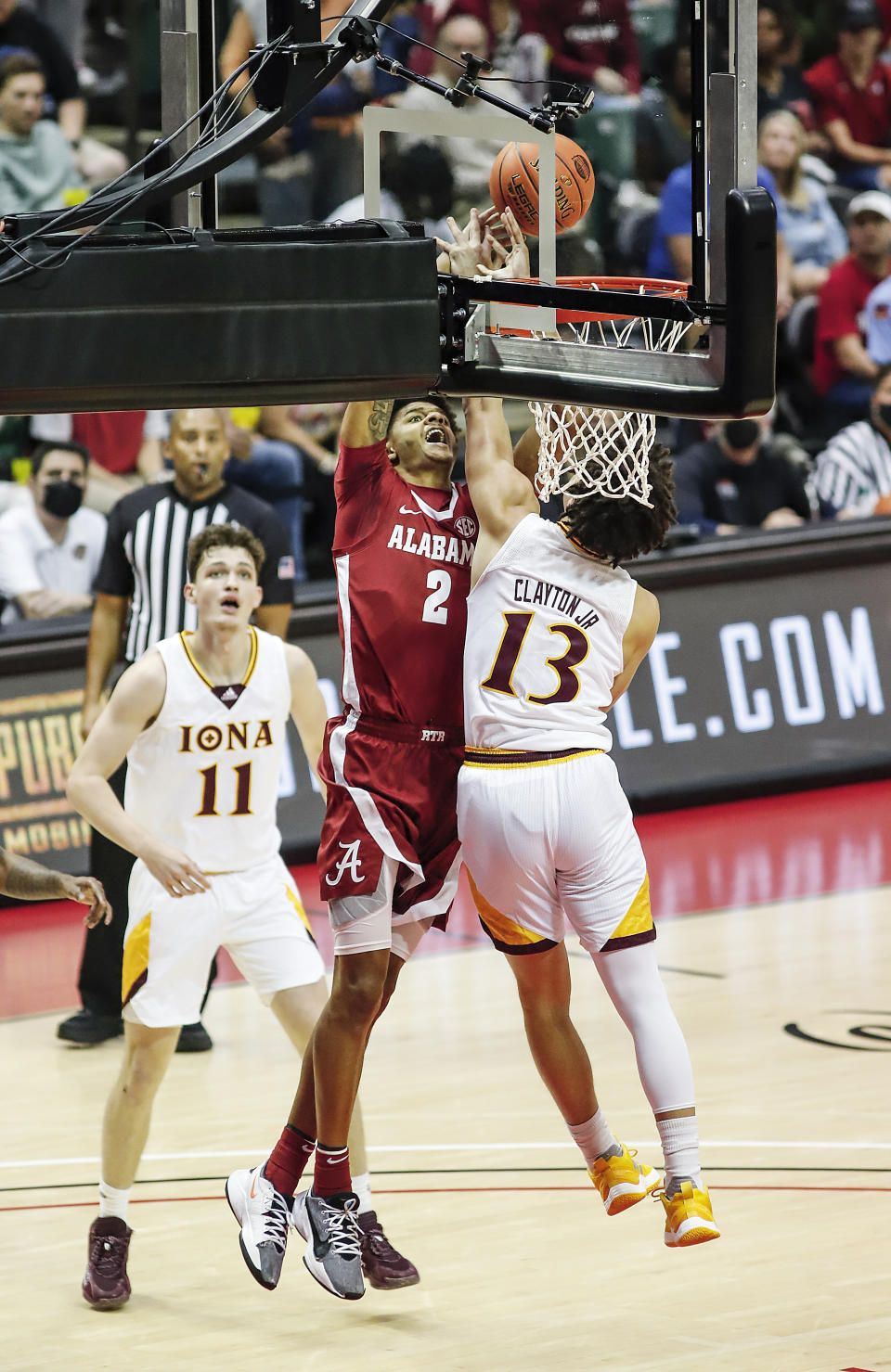 Alabama forward Darius Miles (2) tries to dunk on Iona guard Walter Clayton Jr. (13) as Iona forward Quinn Slazinski, left, looks on during the first half of an NCAA college basketball game Thursday, Nov. 25, 2021, in Orlando, Fla. (AP Photo/Jacob M. Langston)