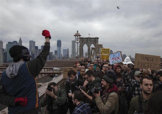 An Occupy Wall Street protester raises his fist towards dozens of fellow activists marching across the Brooklyn Bridge in New York April 1, 2012.