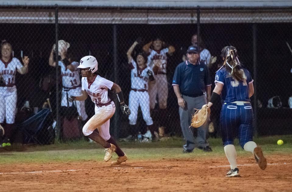 The throw gets away from third baseman Jasmine Johnson (1)  allowing Taylor Jefferson (16) to head home for the game winning run in the bottom of the 7th inning during the Gulf Breeze vs Navarre softball game at Navarre High School on Tuesday, April 26, 2022.  The Raiders won 2-1.