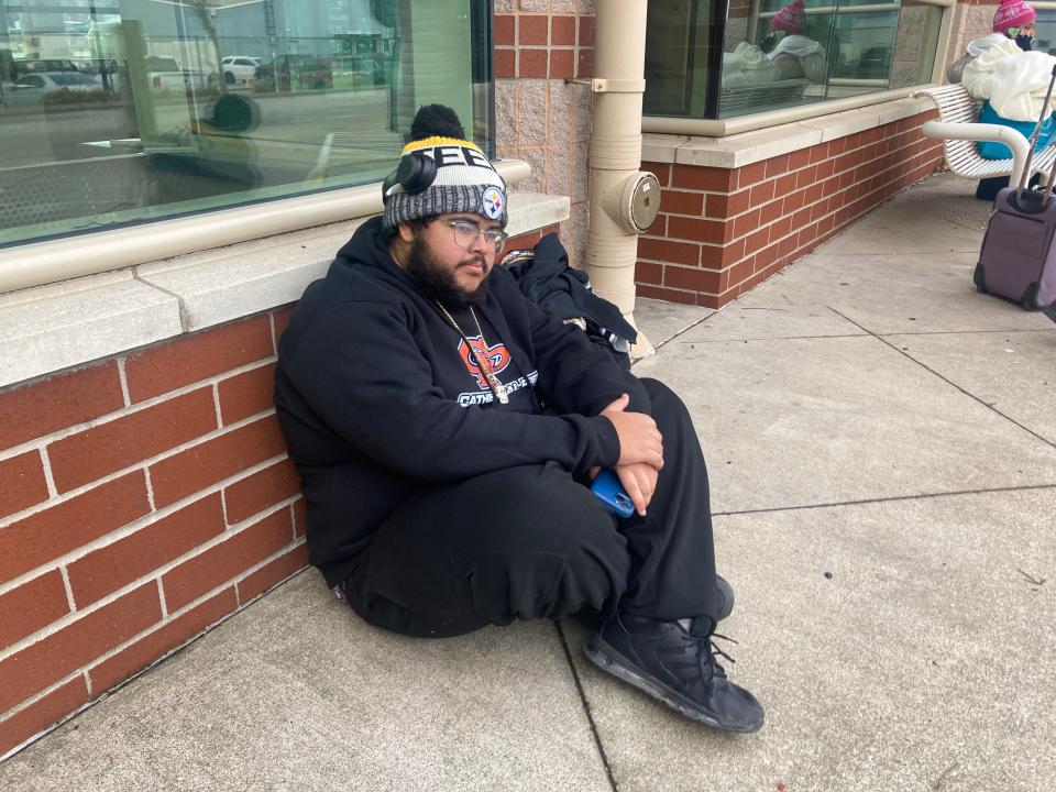 Eric Libreros waits outside the Greyhound bus station on Erie's bayfront on Dec. 8, 2022. There has been no public access to the bus station since May.