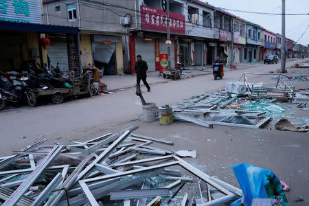 A man walks past damaged buildings following an explosion at a pesticide plant owned by Tianjiayi Chemical nearby, in Xiangshui county, Yancheng, Jiangsu province, China March 22, 2019. REUTERS/Aly Song