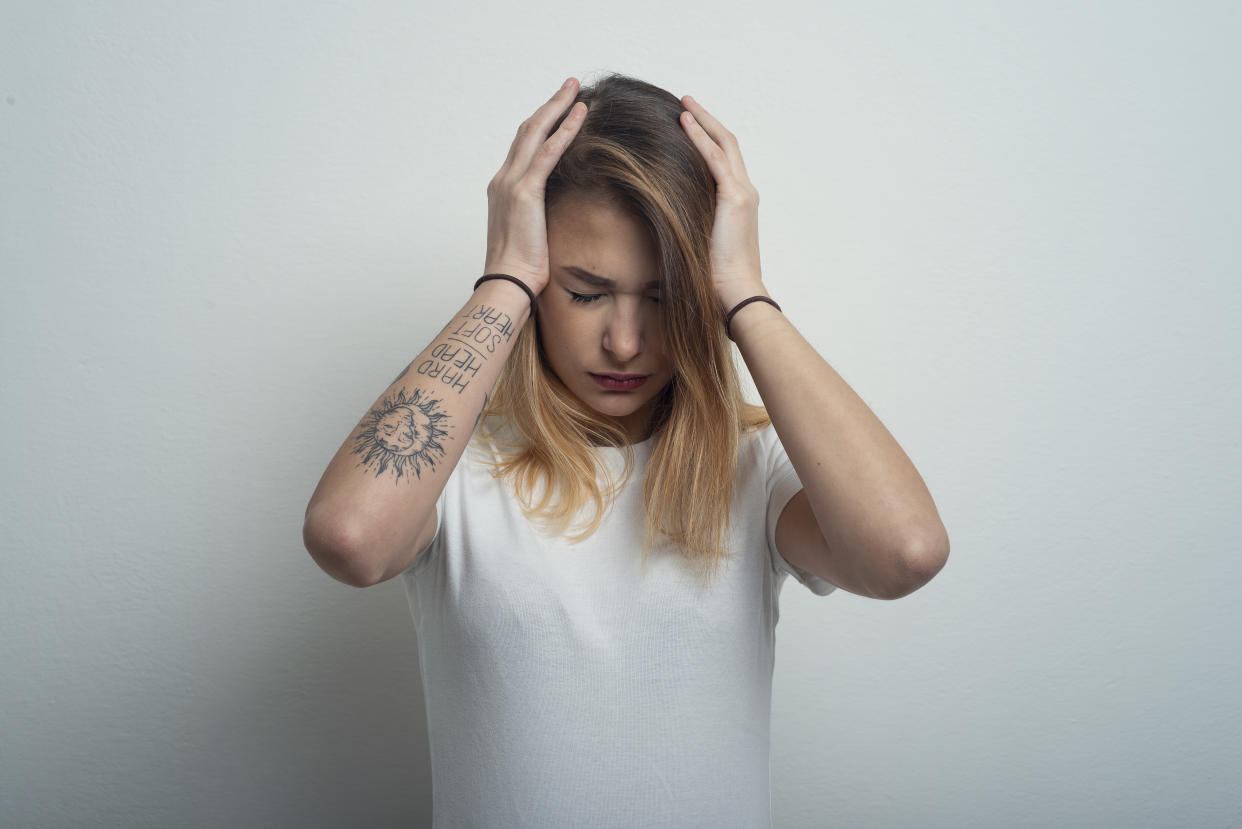 Woman With Headache Against light Blue Background. Studio shot