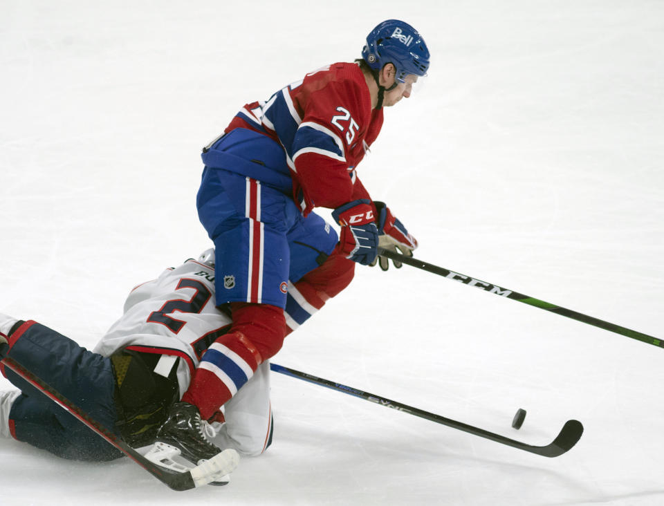 Columbus Blue Jackets defenseman Adam Boqvist (27) takes down Montreal Canadiens right wing Denis Gurianov (25) as they battle for the puck during second-period NHL hockey game action in Montreal, Saturday, March 25, 2023. (Peter McCabe/The Canadian Press via AP)