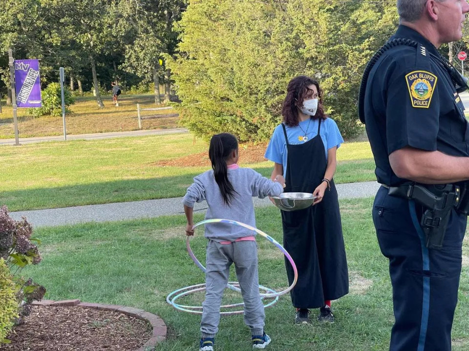 A child who arrived by plane with a group of immigrants plays with hula hoops outside the high school in Martha’s Vineyard, Massachusetts, on Wednesday, Sept. 14, 2022.