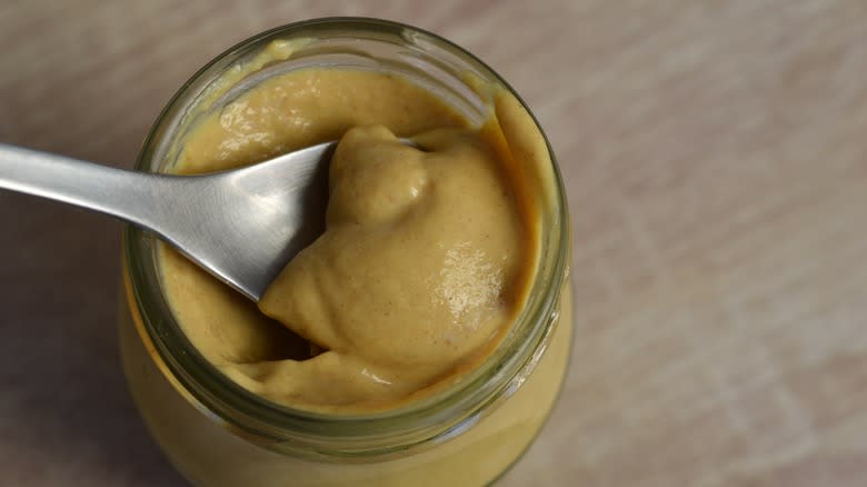 spoon in dijon mustard jar