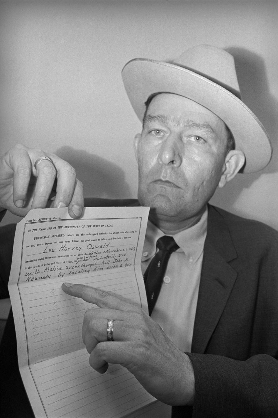 <p>District Attorney Bill Alexander holds an affidavit charging Lee Harvey Oswald with the assassination of President John F. Kennedy on Nov. 22, 1963. (Photo: Bettmann/Getty Images) </p>