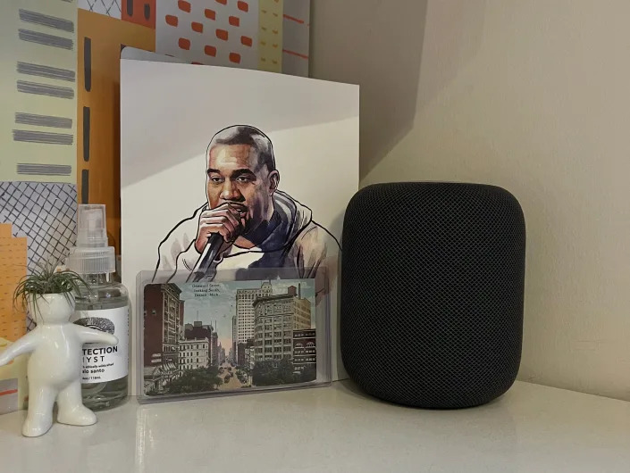 Corner of room with figurine, speaker, and portrait of Kanye West