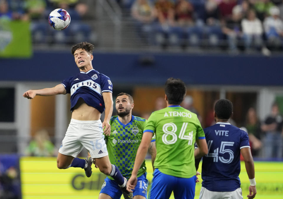 Vancouver Whitecaps midfielder Sebastian Berhalter heads the ball as Seattle Sounders forward Jordan Morris (13) watches during the first half of an MLS soccer match Saturday, Oct. 7, 2023, in Seattle. (AP Photo/Lindsey Wasson)