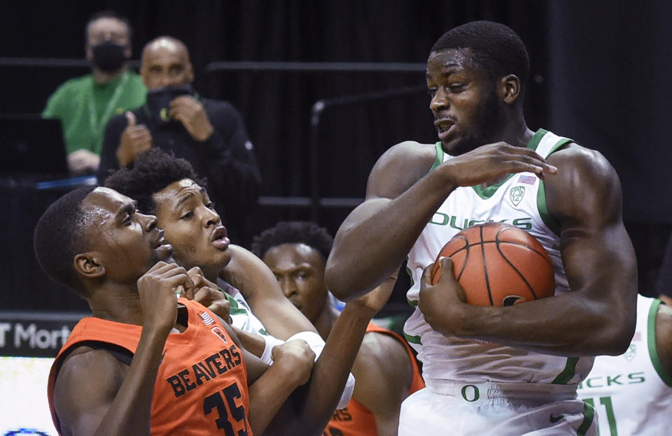 Oregon forward Eugene Omoruyi (2) comes down with a rebound next to Oregon State forward Dearon Tucker (35) during the first half of an NCAA college basketball game Saturday, Jan. 23, 2021, in Eugene, Ore. (AP Photo/Andy Nelson)