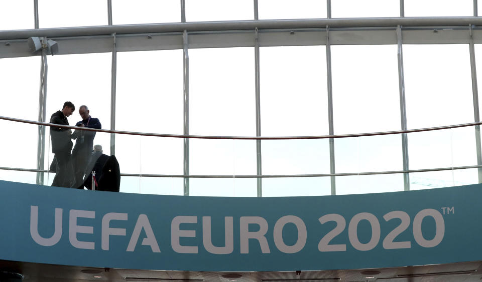 People look from a balcony with UEFA Euro 2020 soccer championship branding at the Convention Centre, Dublin, Sunday December 2, 2018, ahead of the UEFA Euro 2020 qualifying draw, at the Convention Centre in Dublin, Ireland, Sunday, Dec. 2, 2018. (Brian Lawless/PA via AP)