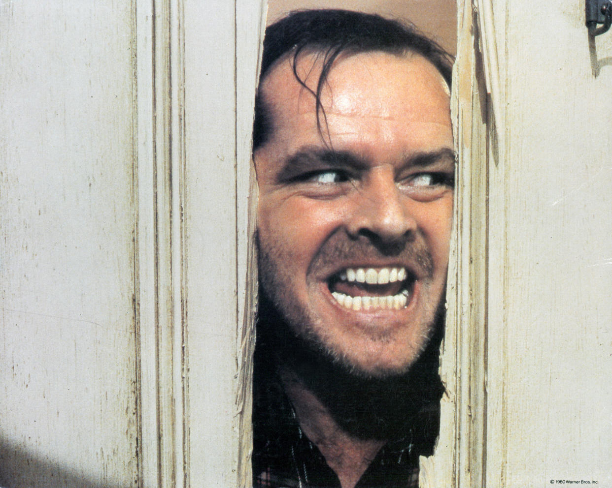 Jack Nicholson peering through axed in door in lobby card for the film 'The Shining', 1980. (Photo by Warner Brothers/Getty Images)