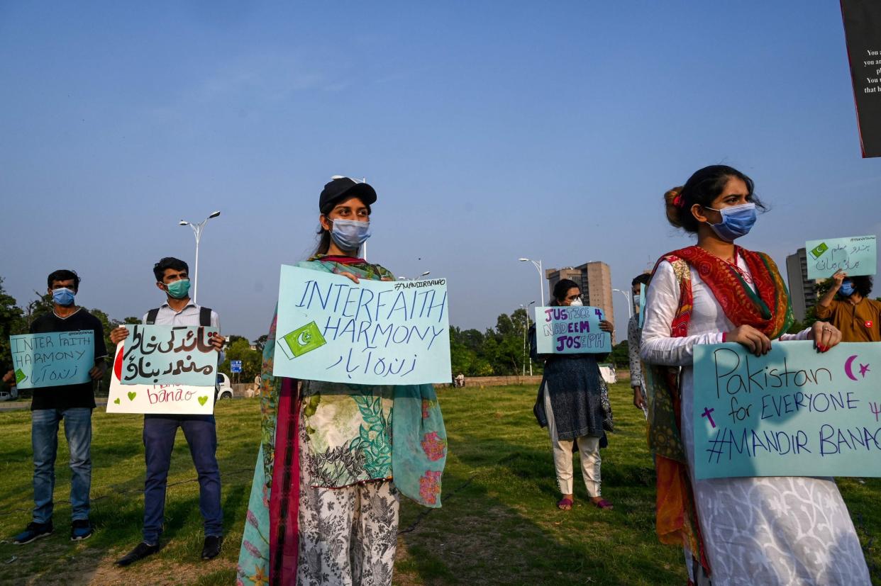 Demonstrators hold placards during a protest in support of the Islamabad temple's construction on Wednesday 8 July: AFP via Getty Images