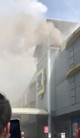 Smoke billows from a building on fire in Davao, the Philippines, in this still image taken a December 23, 2017 social media video. @Clarkydoodle/via REUTERS