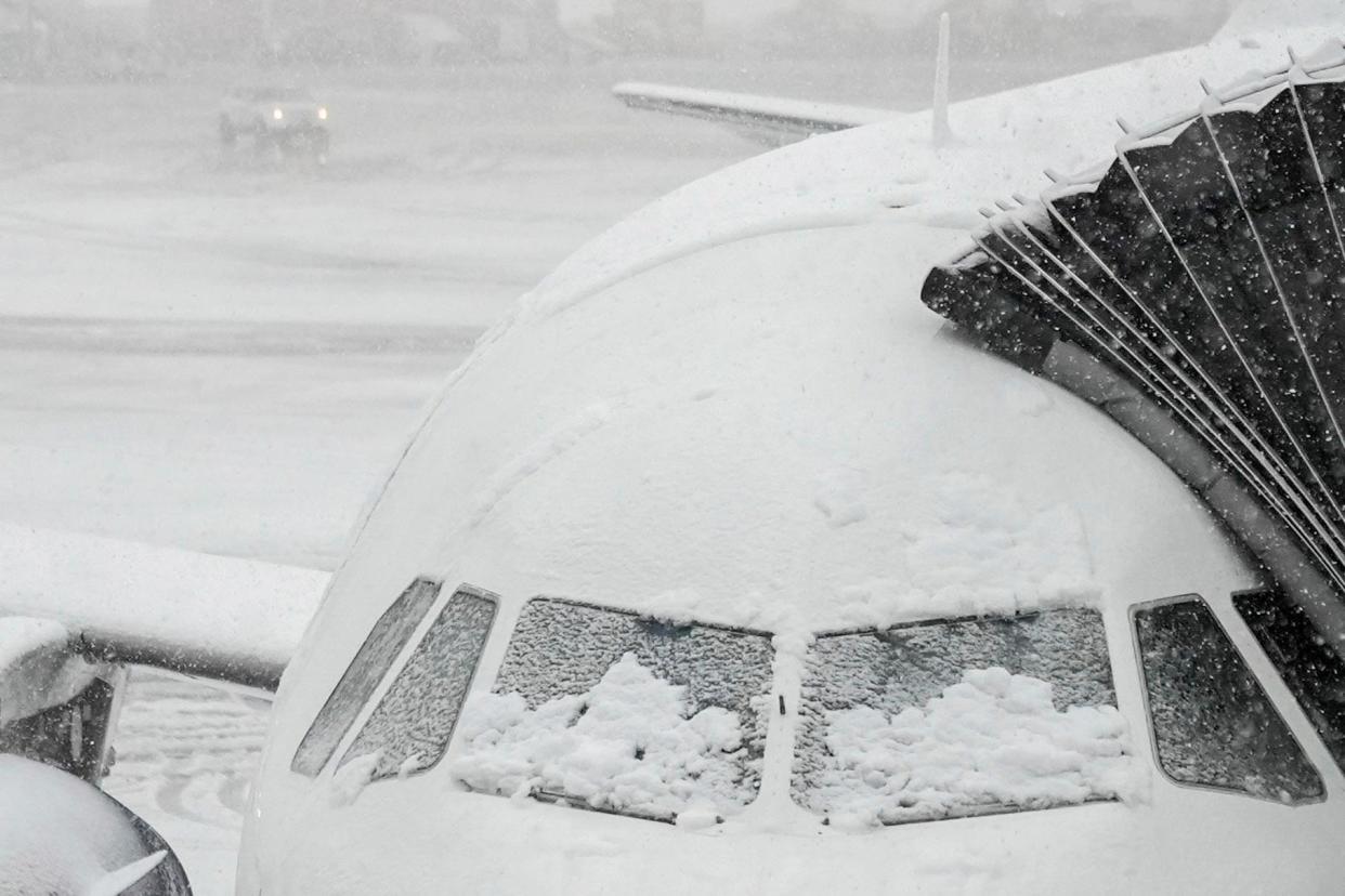 <span>Snow covers a plane at John F Kennedy international airport on Tuesday.</span><span>Photograph: Frank Franklin II/AP</span>