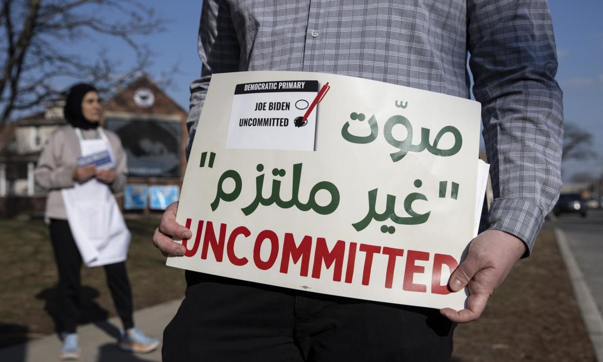 <span>A volunteer with Listen to Michigan near a voting site in Dearborn, Michigan, on 27 February 2024.</span><span>Photograph: Anadolu/Getty Images</span>