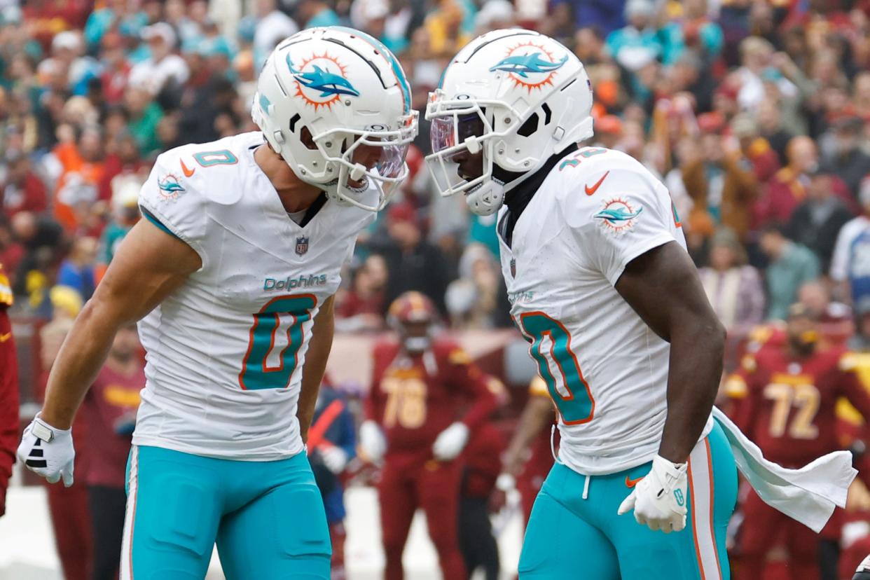 Dec 3, 2023; Landover, Maryland, USA; Miami Dolphins wide receiver Tyreek Hill (10) celebrates with Dolphins wide receiver Braxton Berrios (0) after catching a touchdown pass against the Washington Commanders during the first quarter at FedExField. Mandatory Credit: Geoff Burke-USA TODAY Sports