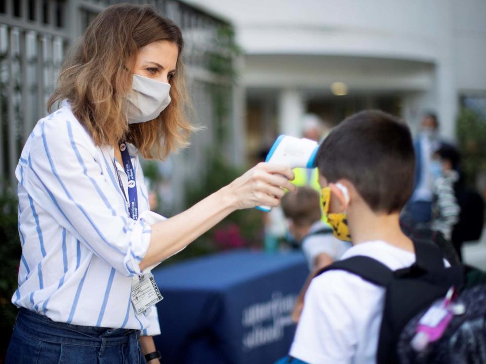 A child has his temperature taken at the entrance to a school in Spain as the country experiences a second wave of coronavirus with near-record numbers of daily cases: EPA/Marta Perez