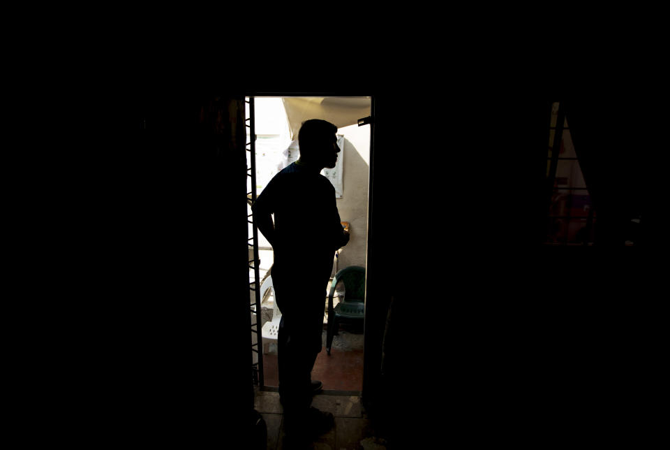 In this Sept. 18, 2019 photo, Nicaraguan migrant Yohan speaks with a new arrival to a migrant shelter where he lives with his family in Monterrey, Mexico. The 31-year-old Nicaraguan security guard trudged back across the border bridge from Laredo, Texas, in July with his wife and two children in tow, clutching a plastic case full of documents including one with a court date to return and make their asylum claim to a U.S. immigration judge two months later. (AP Photo/Fernando Llano)