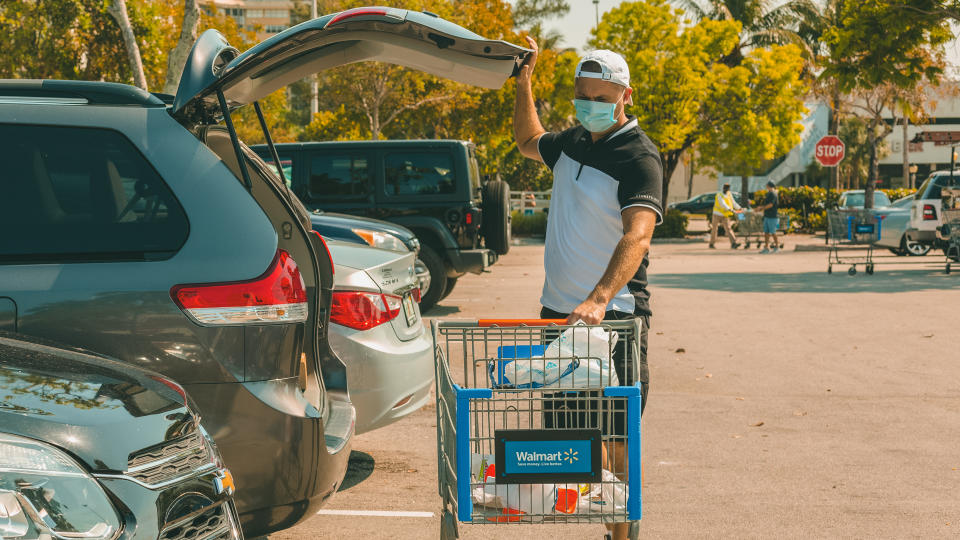 Miami, FL, USA - March 26, 2020:Man wearing medical mask on Walmart store parking space.