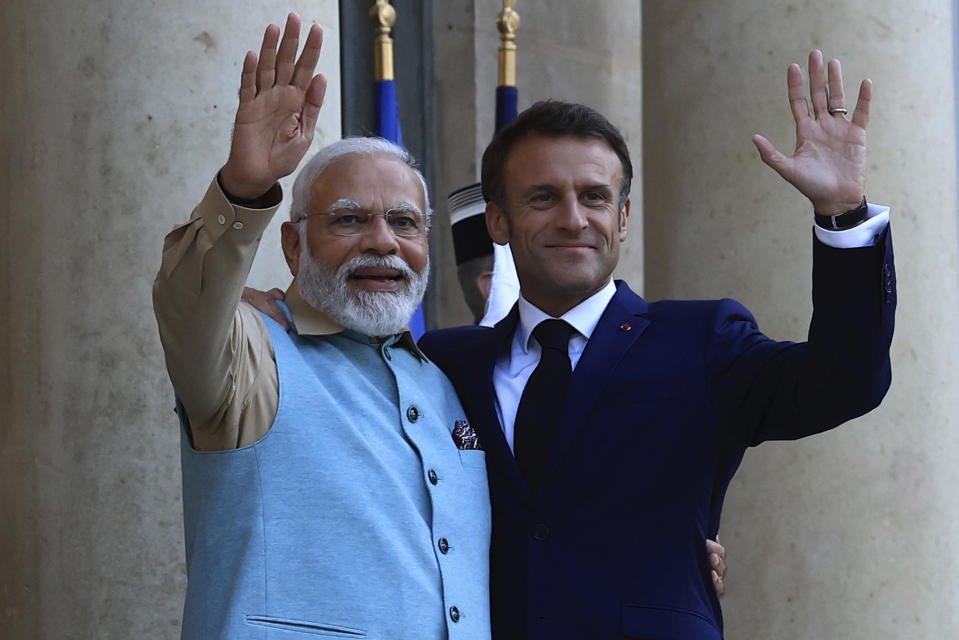 French President Emmanuel Macron and Indian Prime Minister Narendra Modi wave before a working dinner, Thursday, July 13, 2023 at the Elysee Palace, in Paris. Narendra Modi is on a two-day visit and will attend Bastille Day parade with French President Emmanuel Macron on Friday. (AP Photo/Aurelien Morissard)