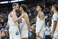 Gonzaga forward Drew Timme, left, hugs with teammates while checking out of the game during the final minutes in the second half of an Elite 8 college basketball game against UConn in the West Region final of the NCAA Tournament, Saturday, March 25, 2023, in Las Vegas. (AP Photo/David Becker)
