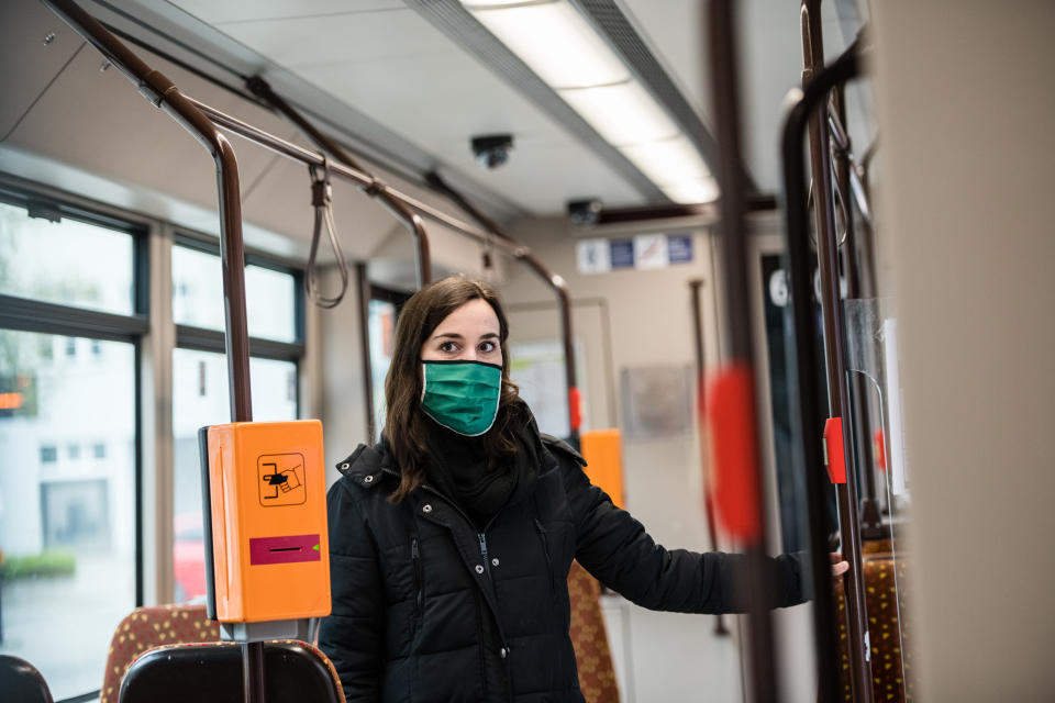 JENA, GERMANY - APRIL 03: Sophie Frick wears a protective face masks in a tram at a press meeting of the transport companie 'Jenaer Nahverkehr' on April 3, 2020 in Jena, Germany. A three-part city ordinance is going into effect requiring people to wear protective face masks under circumstances that include shopping, riding public transport and workplaces where social distancing is difficult. A face mask requirement is a current issue of controversy across Germany, with the federal government so far declining to make wearing one in public mandatory. Germany is struggling with a shortage of face masks, and the requirement in Jena also allows the use of scarves and other materials to shield one's face as a means to reduce the risk of anyone infected with Covid-19 from infecting others. (Photo by Jens Schlueter/Getty Images)