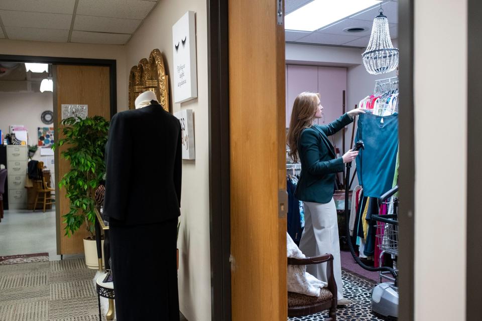 Jenna Holt, Chevrolet assistant retail planning manager who volunteers at Dress for Success Michigan, uses a steamer to get wrinkles out of clothes at the warehouse in Ypsilanti on Tuesday, Dec. 12, 2023.