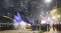 Indonesian riot police fire tear gas to disperse student protesters during a clash outside parliament in Jakarta, Indonesia, Tuesday, Sept. 24, 2019. Police fired tear gas and water cannons Tuesday to disperse thousands of rock-throwing students protesting a new law that they said has crippled Indonesia's anti-corruption agency. (AP Photo/Achmad Ibrahim)