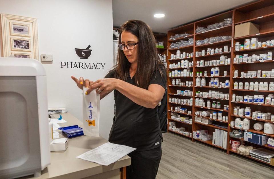 La farmacéutica Leyanys Santos prepara medicamentos en la farmacia de la clínica Dr. GoodPrice, que atiende a familias de inmigrantes sin seguro médico ni cita.