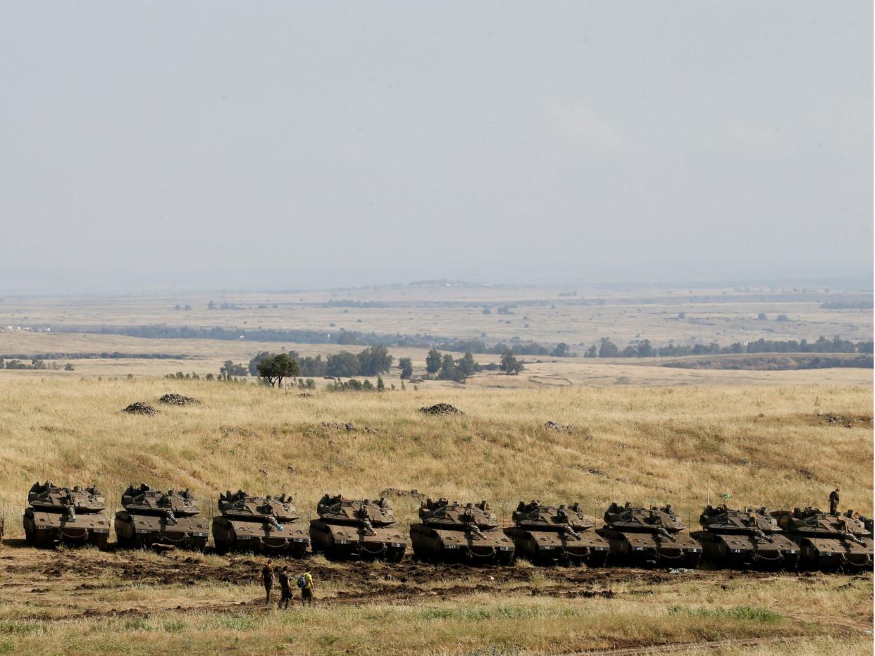 Israeli soldiers walk past tanks near the border with Syria in the Golan Heights: Reuters