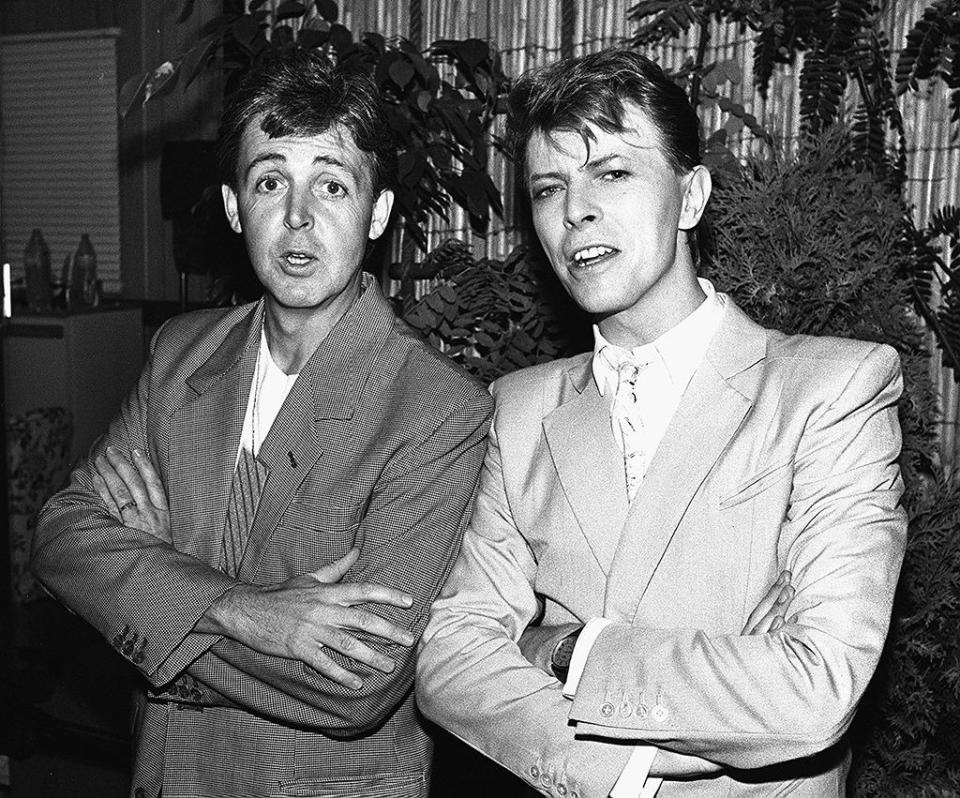 Bowie poses with Paul McCartney backstage at Wembley Stadium in London for Live Aid, 1985. The intercontinental televised famine relief concert drew an audience of an estimated 1.9 billion viewers.
