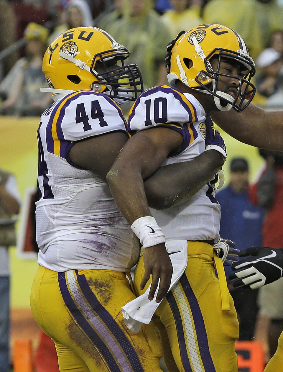 LSU quarterback Anthony Jennings (10) gets a hug from teammate fullback J.C. Copeland (44) after Jenning scored on a 2-yard touchdown run during the first quarter of the Outback Bowl NCAA college football game against Iowa Wednesday, Jan. 1, 2014, in Tampa, Fla. (AP Photo/Chris O'Meara)