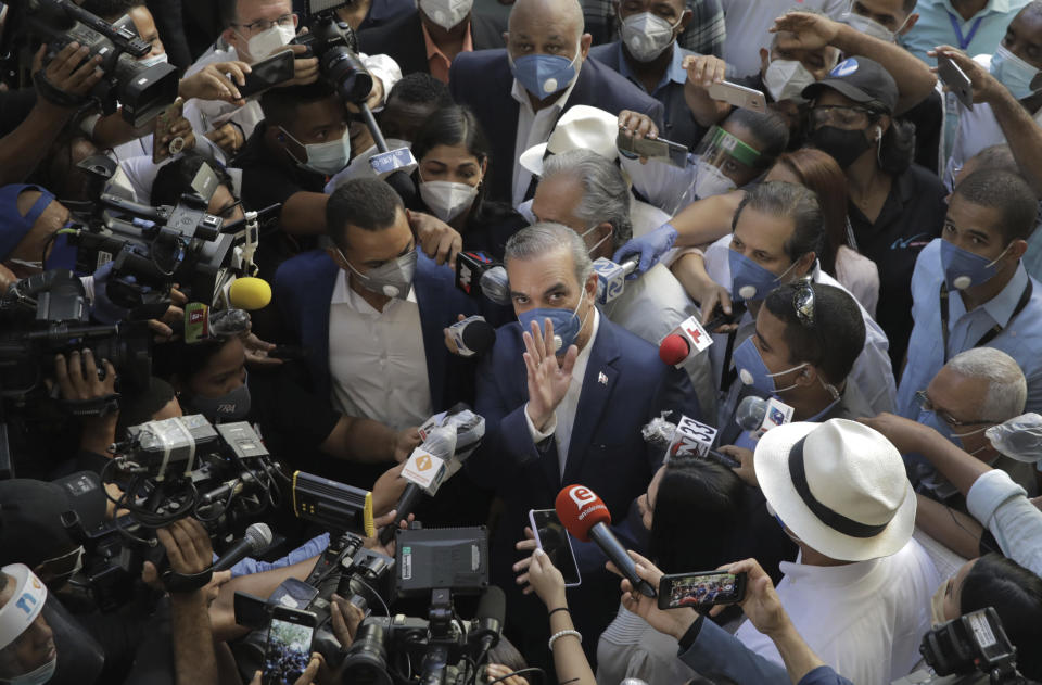 Luis Abinader, presidential candidate of the opposition Modern Revolutionary Party, greets the crowd while he is surrounded by journalists at a voting center during the presidential elections, in Santo Domingo, Dominican Republic, Sunday, July 5, 2020. (AP Photo/Tatiana Fernandez)