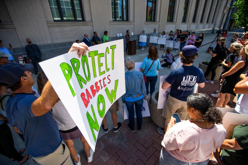 People hold signs and listen to speakers Monday during a rally celebrating overturning Roe v. Wade near the Robert A. Grant Federal Building & U.S. Courthouse in downtown South Bend.