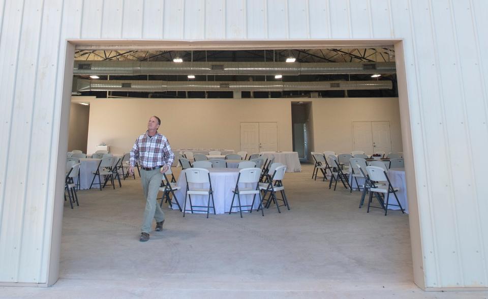 Kyle Holley, Santa Rosa County Fair Board volunteer project manager, prepares to close the rollup door at the new exhibit hall and event space at the AGRI-PLEX in November 2021. The county is looking to use both county and state funding to increase capacity at the site and has plans to build another structure on the property.