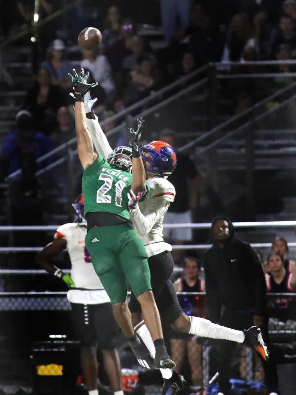 Venice defensive back Elliot Washington (21) reaches for the ball ahead of West Orange receiver Jayden Gibson (1) on a mid-air interception in the end zone during Class 8A-Region 3 playoff football action in Venice. MATT HOUSTON/HERALD-TRIBUNE