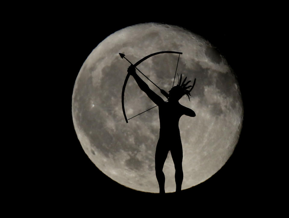 <p>A waning full moon rises behind a statue of a Kansa Indian on top of the Kansas Statehouse, Sept. 17, 2016, in Topeka, Kan. (Photo: Charlie Riedel/AP) </p>