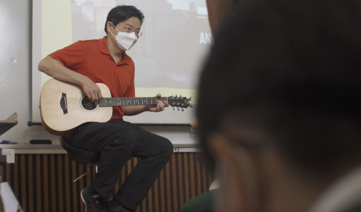 Deputy Prime Minister Lawrence Wong plays the guitar in a class with current Tanjong Katong Secondary School students during an interview with presenter Tung Soo Hua. (SCREENCAP: MeWatch)