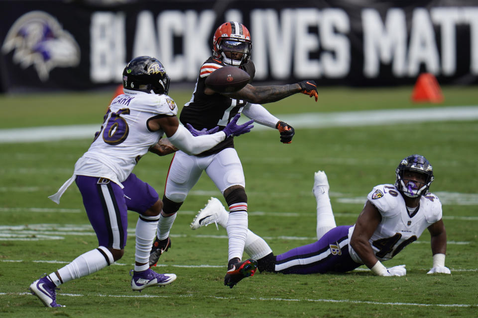 Baltimore Ravens safety Chuck Clark (36) attempts to intercept the ball as Cleveland Browns wide receiver Odell Beckham Jr. (13) tries to hit it away, during the first half of an NFL football game, Sunday, Sept. 13, 2020, in Baltimore, MD. Baltimore Ravens linebacker Malik Harrison (40) in on the ground. (AP Photo/Julio Cortez)